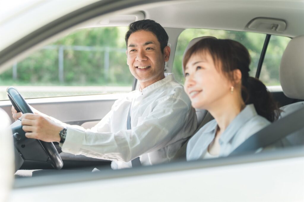 車内で笑顔でドライブを楽しむ夫婦
