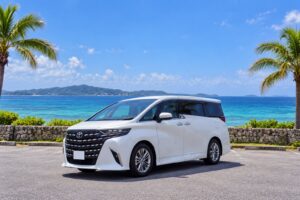 沖縄の海沿いに停まるアルファード40系レンタカー